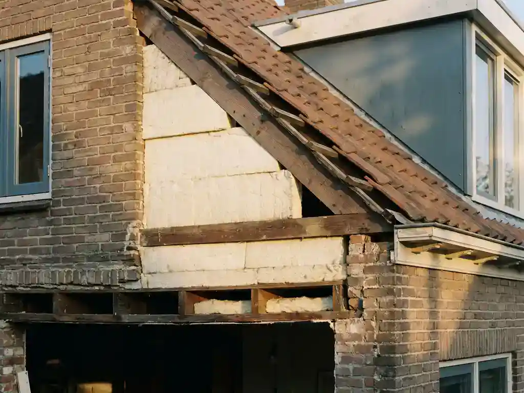 Doorsnede van Nederlandse woning met zichtbare isolatielagen in spouwmuur, dak en kruipruimte, omgeven door baksteen en hout.